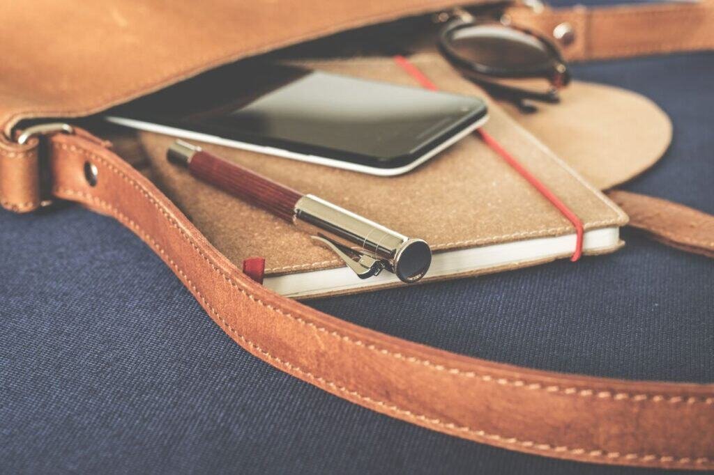 Frameworks & Guides Stylish leather bag with a fountain pen, smartphone, and notebook on display.